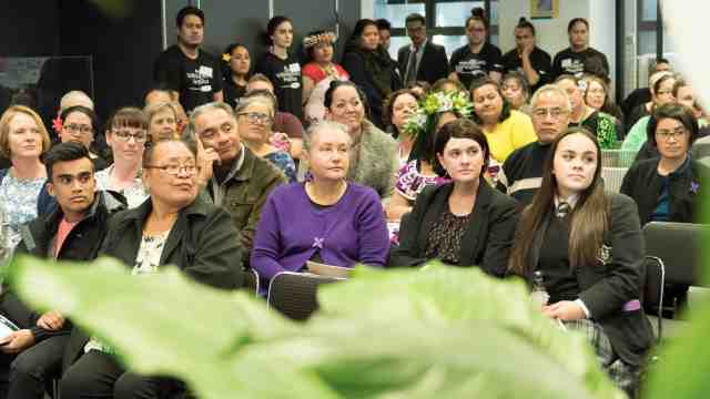 Audience members listening intently.