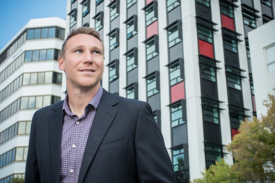 Shaan Cory standing in front of CBD buildings