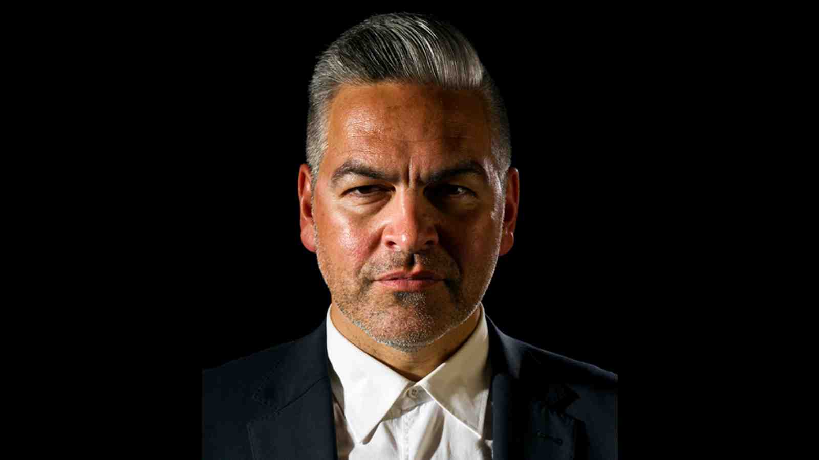 A pofile picture of Victor Rodger wearing a suit in fornt of a black background.