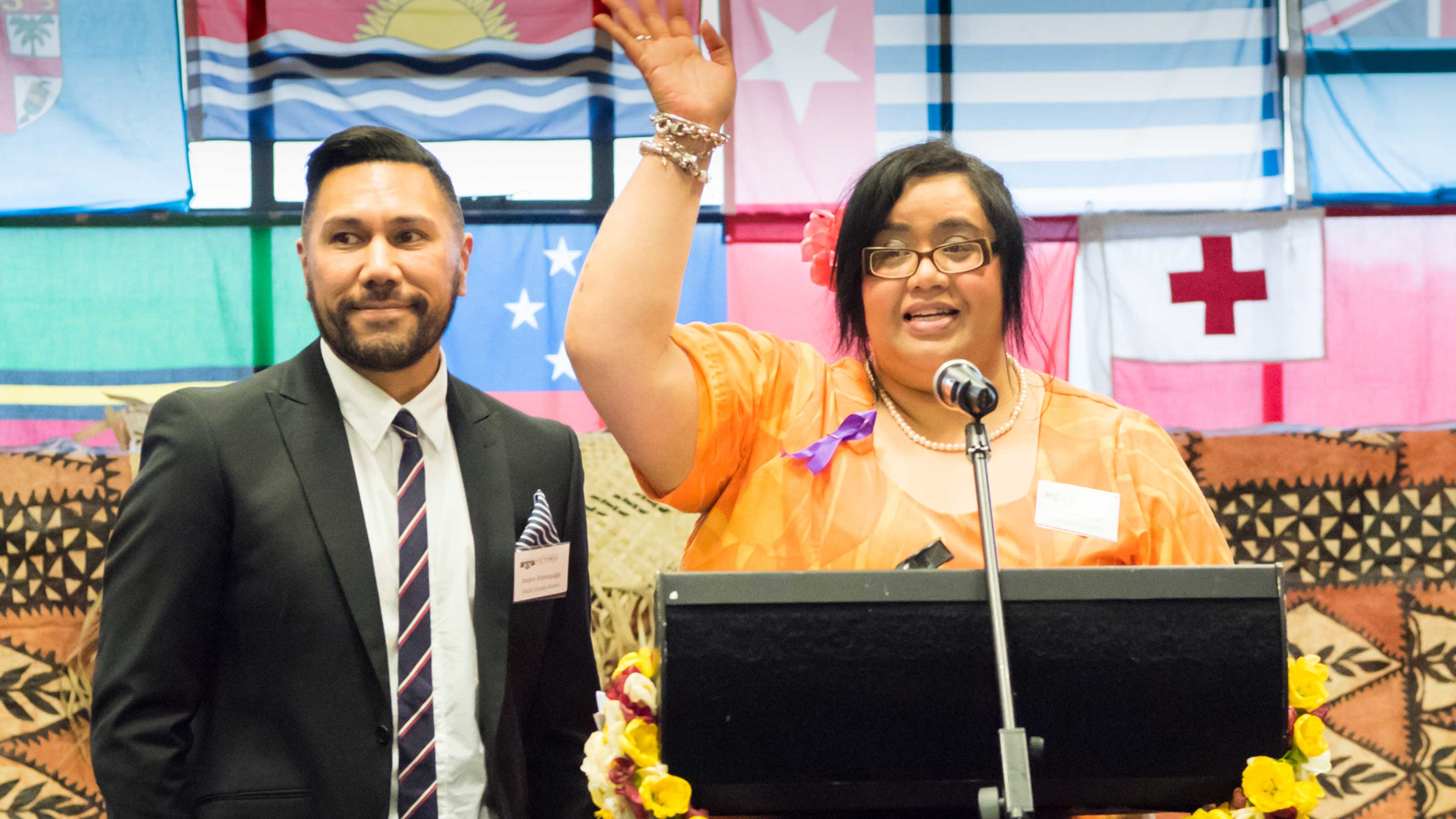 Two people stand behind a podium.