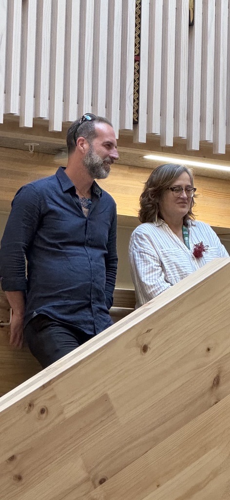 Man and a woman standing on the stairs smiling down