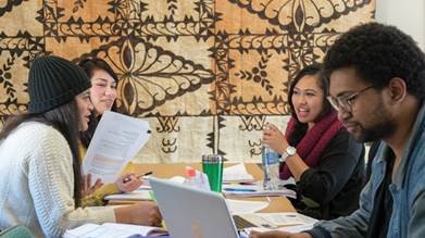 Students study together around a table.