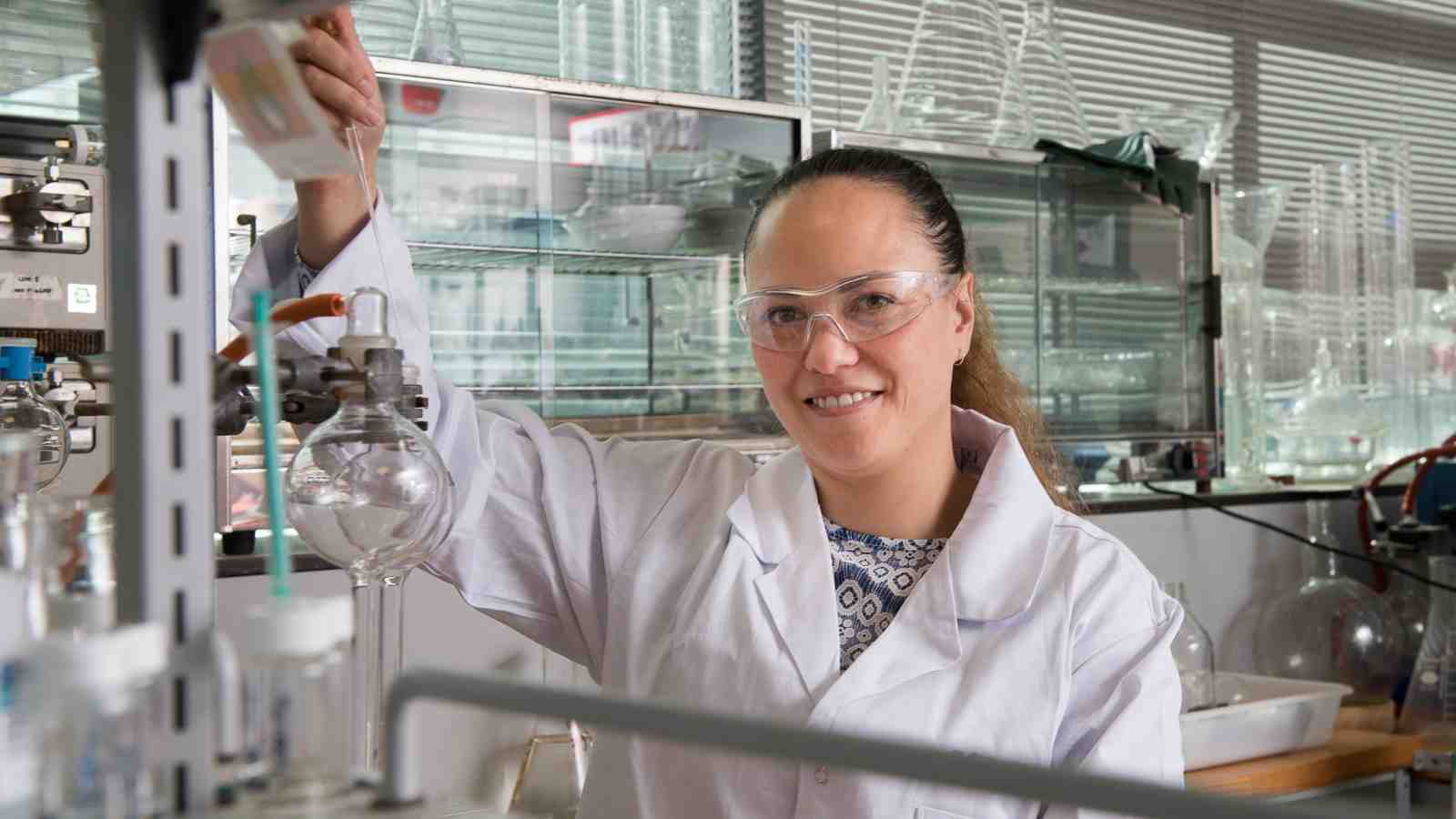 PhD Candidate Helen Woolner uses chemistry equipment in a laboratory.