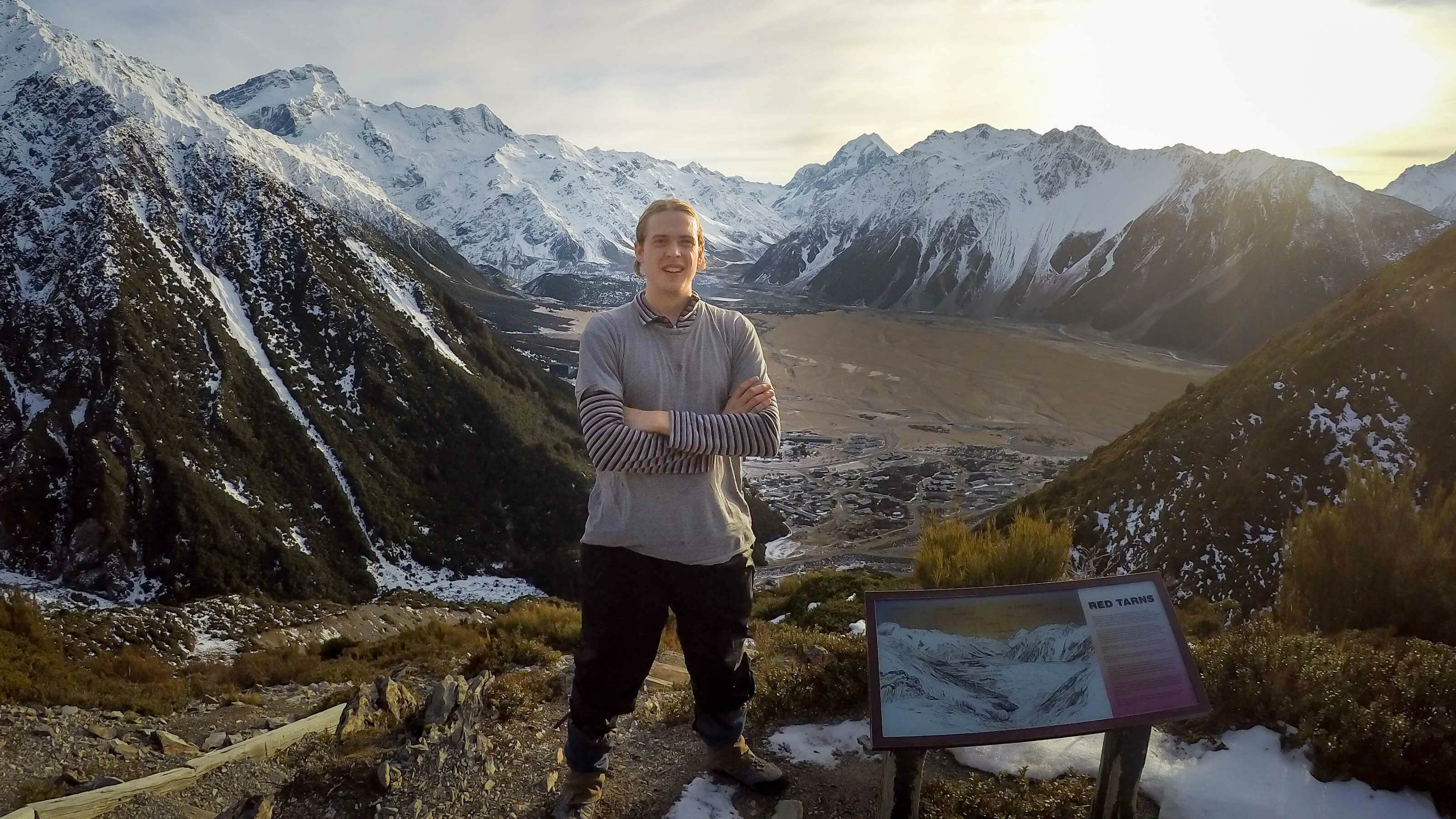 Clarrie Macklin Master of Science in Geophysics, Antarctic Research Centre – stands in front of a snowy mountain range.