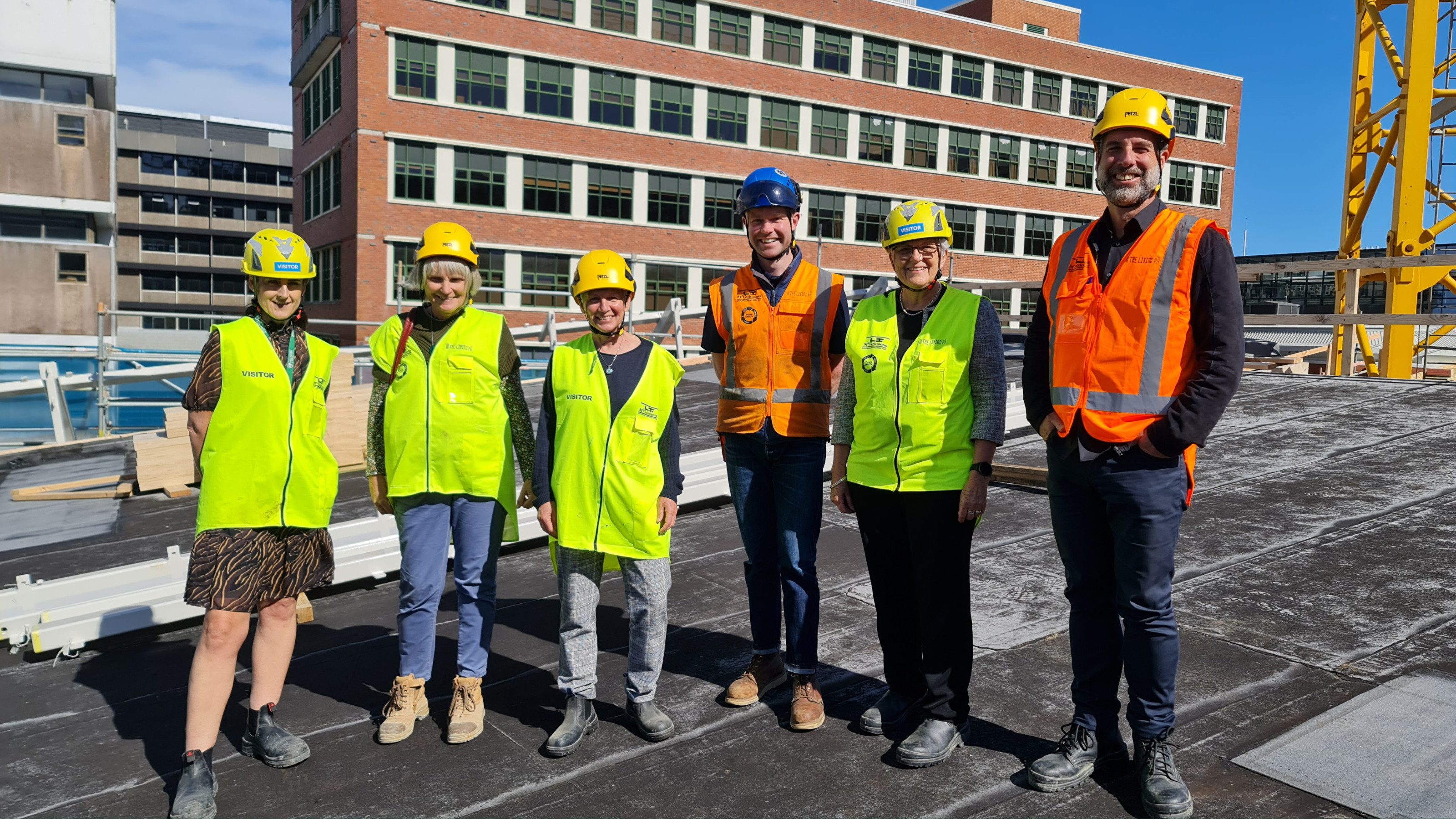 A group of people in hi vis vests and hard hats on a construction site.