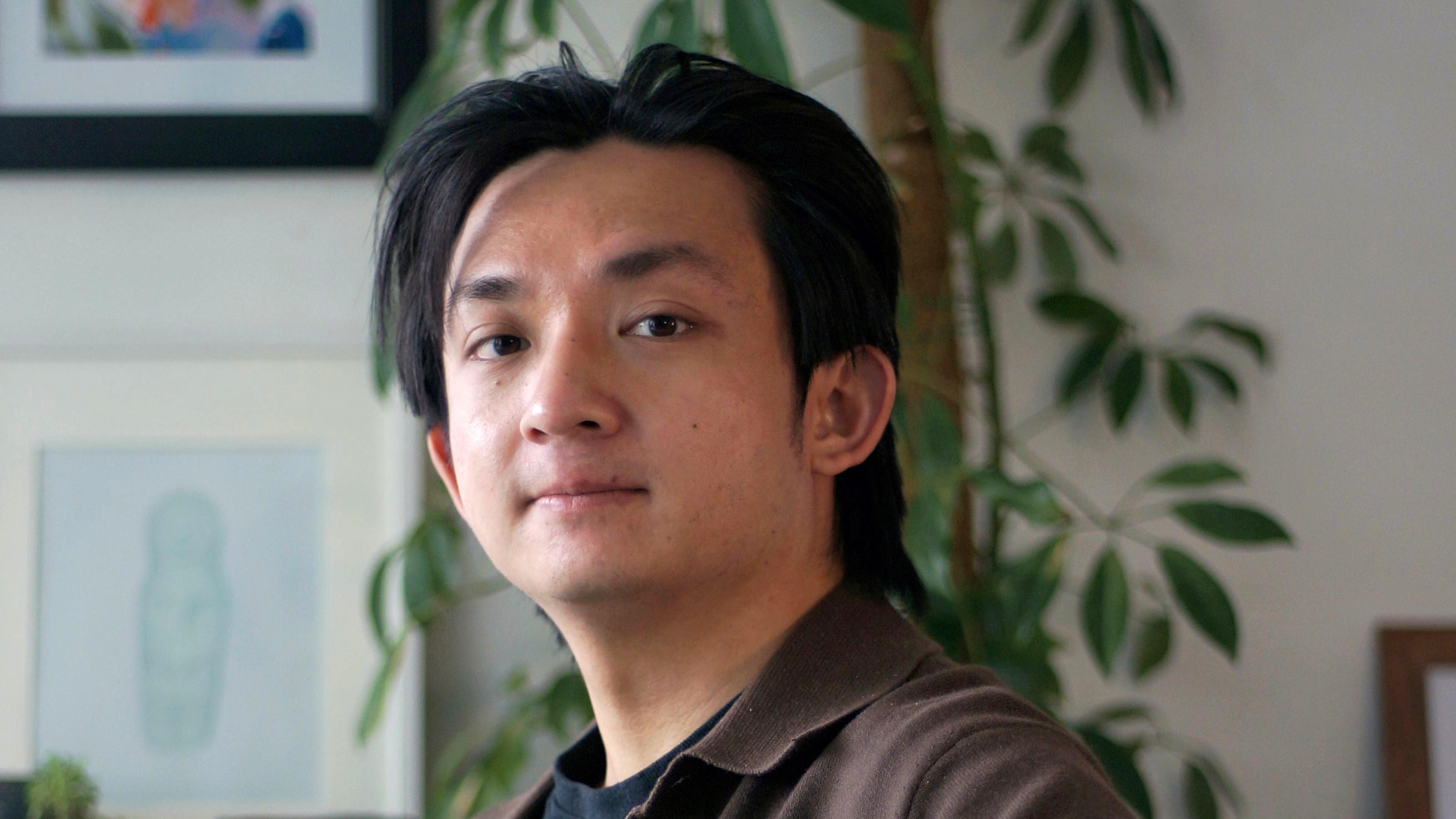 A close up photo of a young man with dark hair.