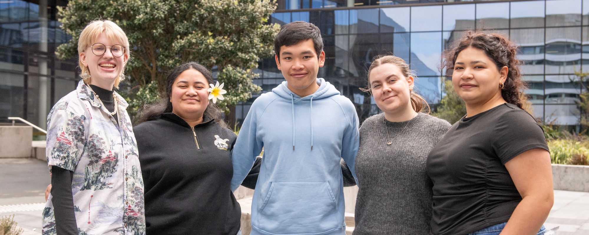 A group of five student ambassadors standing in a row outside.