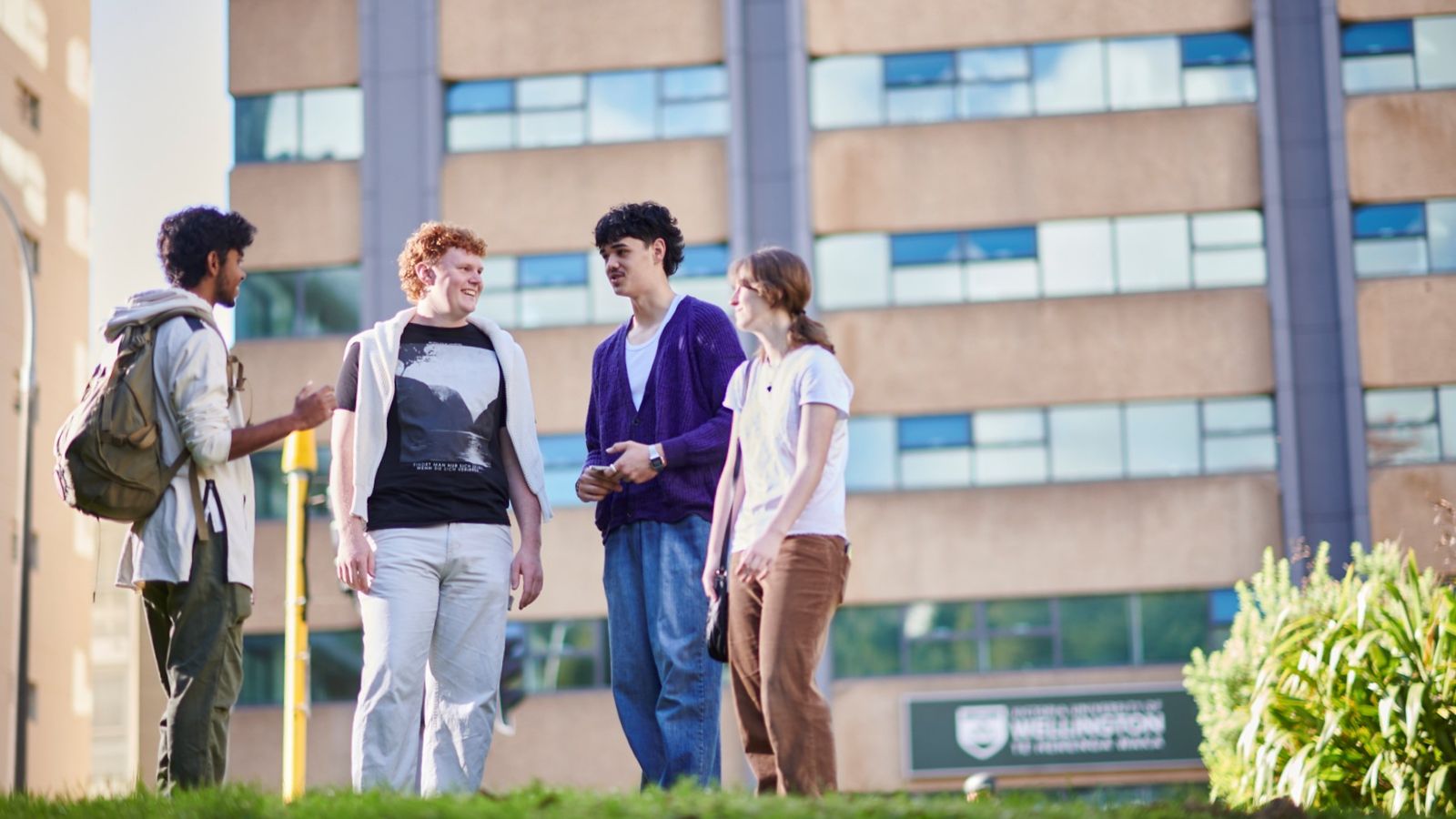 Four hall residents stand outside talking