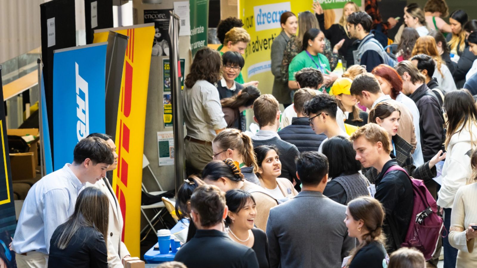 A large crowd of students and employer representatives mingling at a careers expo