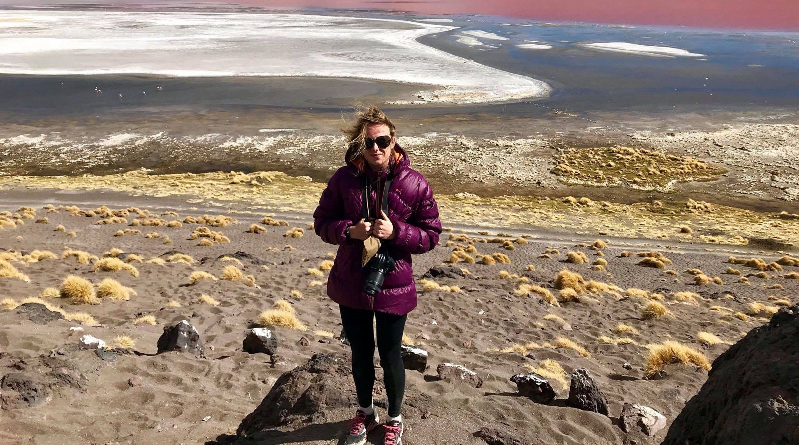 Emma Dent.jpg Emma Dent, wearing black leggings and a purple puffer jacket, stands in rocky, sandy scree.