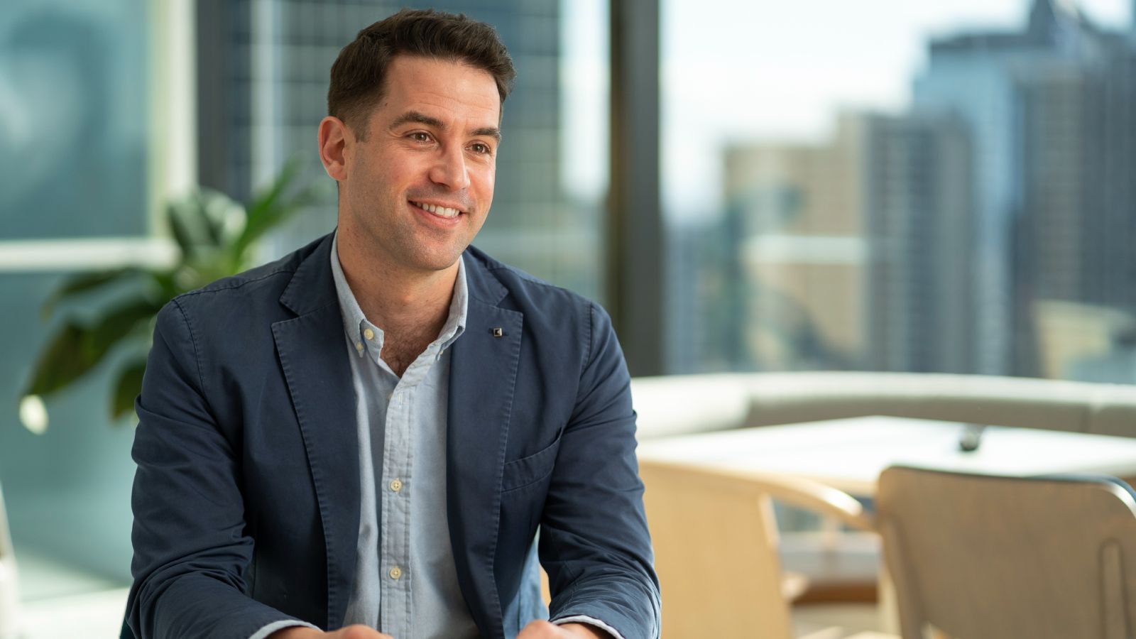 David Herman.jpg Portrait of David Herman, who smiles and looks off camera. David has brown hair and wears a dark blue jacket over a light blue shirt. A skyline of tall buildings can be seen in the out-of-focus background.