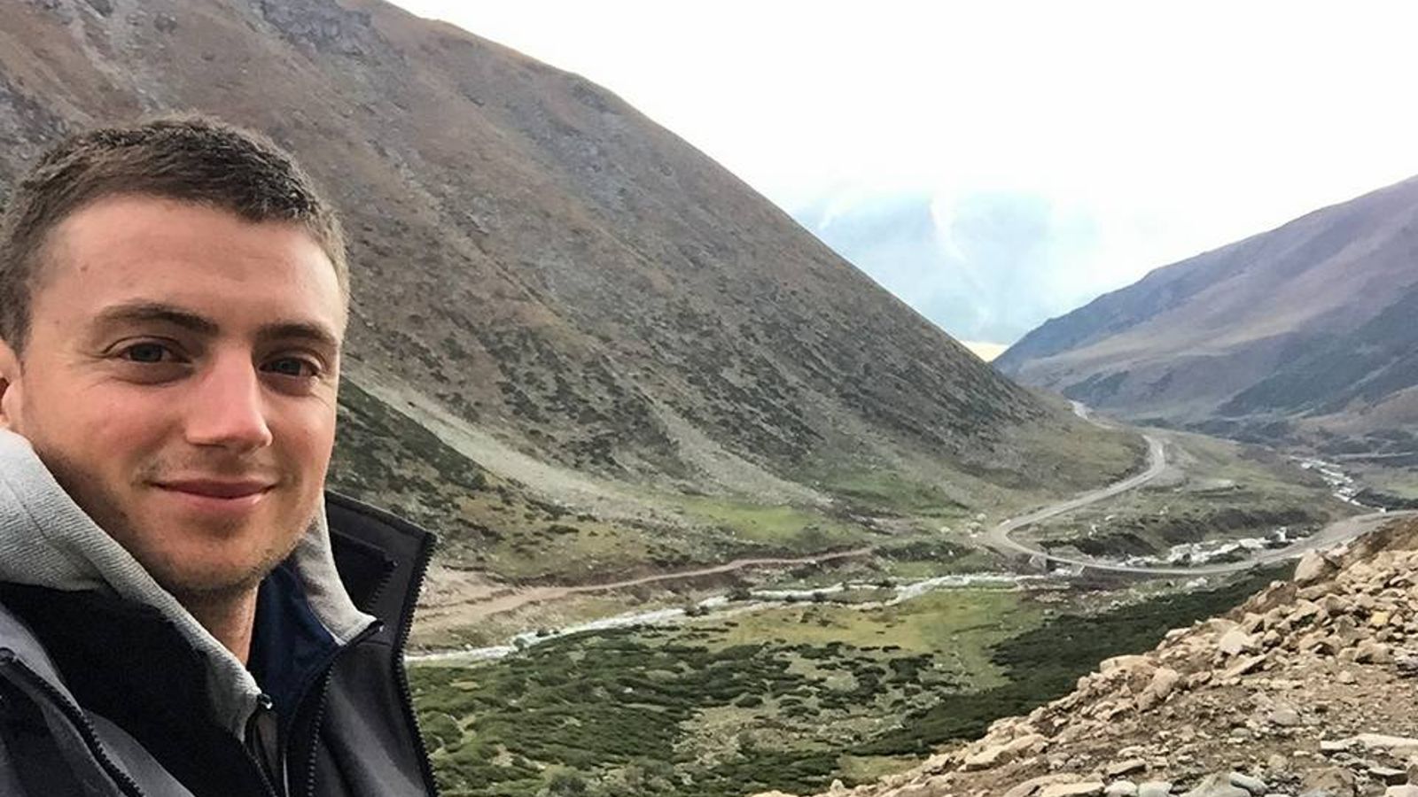 Photo of Kirk McDowall in front of a valley landscape.