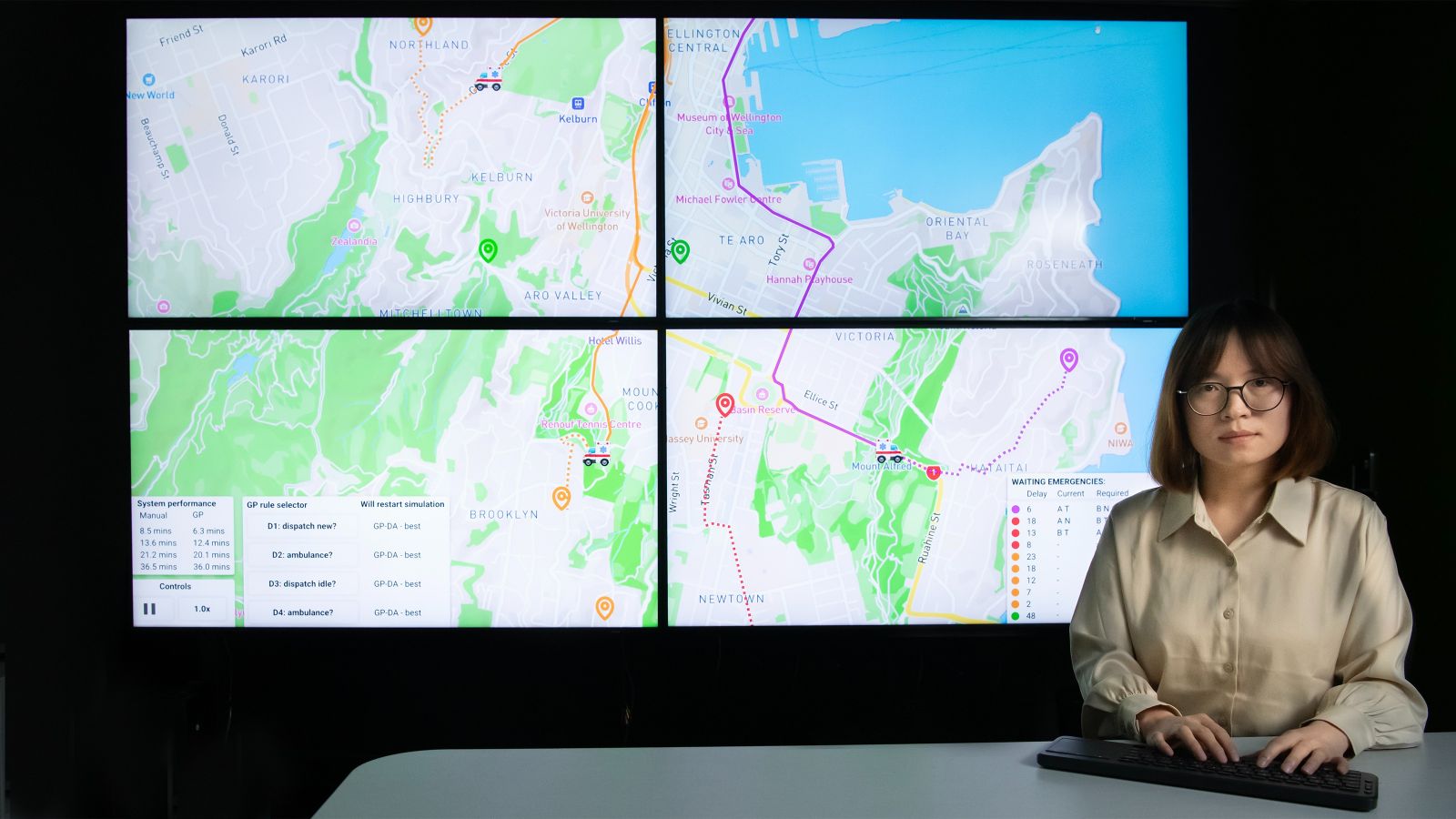 Fang Fang maps Woman in front of multi-screen display of town map