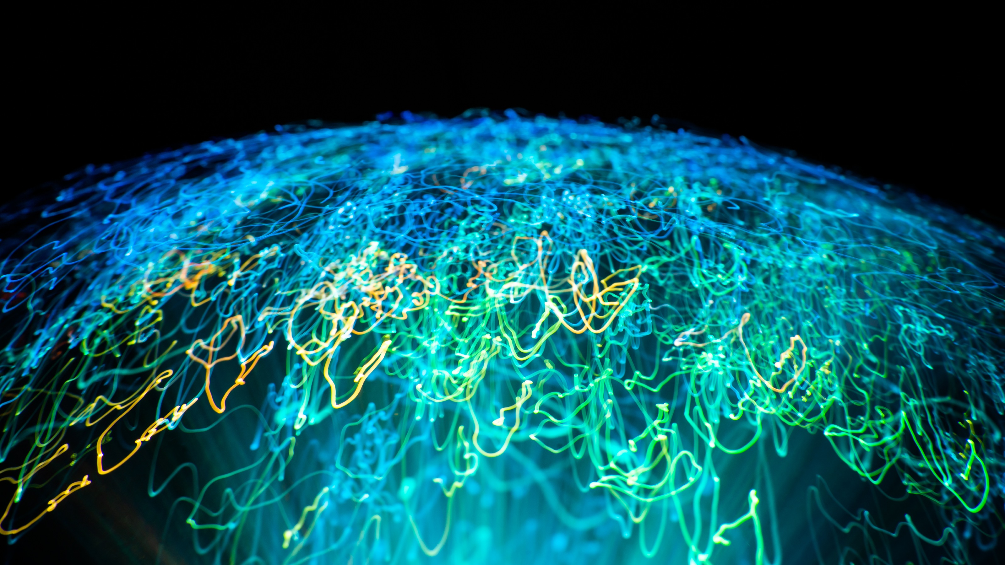 Light scribbles coalesce in shape of globe against dark background