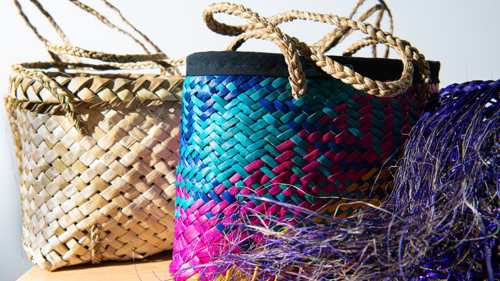 kete.jpg Two kete or woven baskets. One is purple, pink and blue and the other is traditional brown.