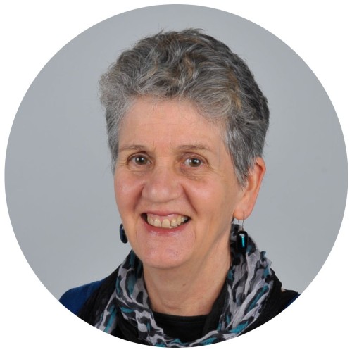 Woman with short grey hair smiling.