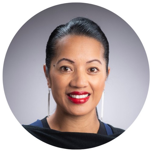 Woman with slick black hair and red lipstick smiling.