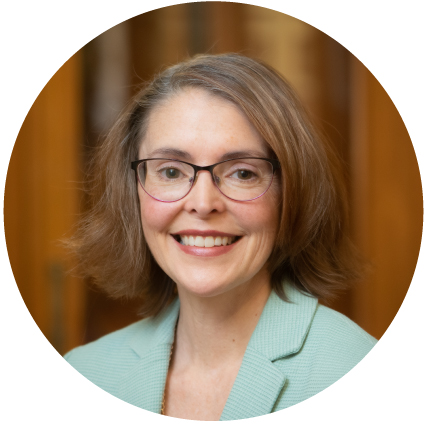 Woman with a short brown bob smiling.