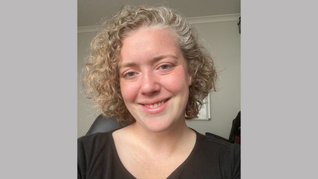 A portrait of Bronwyn who is smiling into the camera