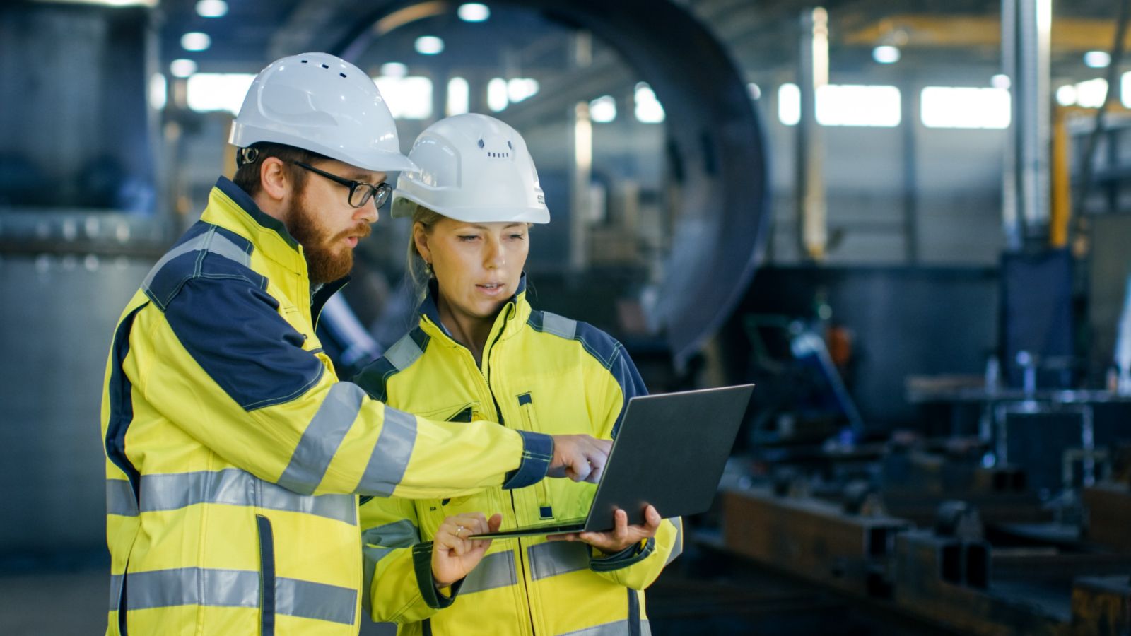 health-and-safety.jpg Two people in hard hats and high vis jackets looking at a laptop together