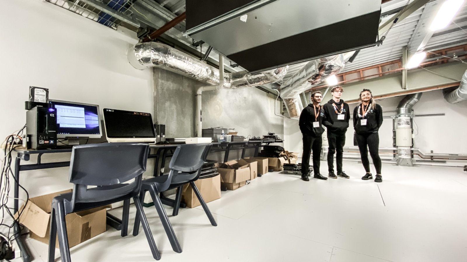 Remojo Tech.jpg A girl and two guys standing in a workshop space