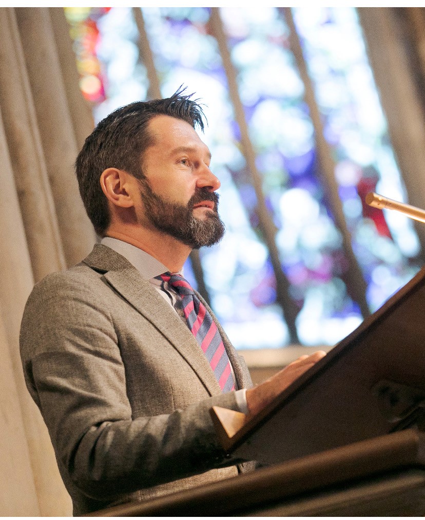 Professor James Lee standing at a lecturn, side-angle shot
