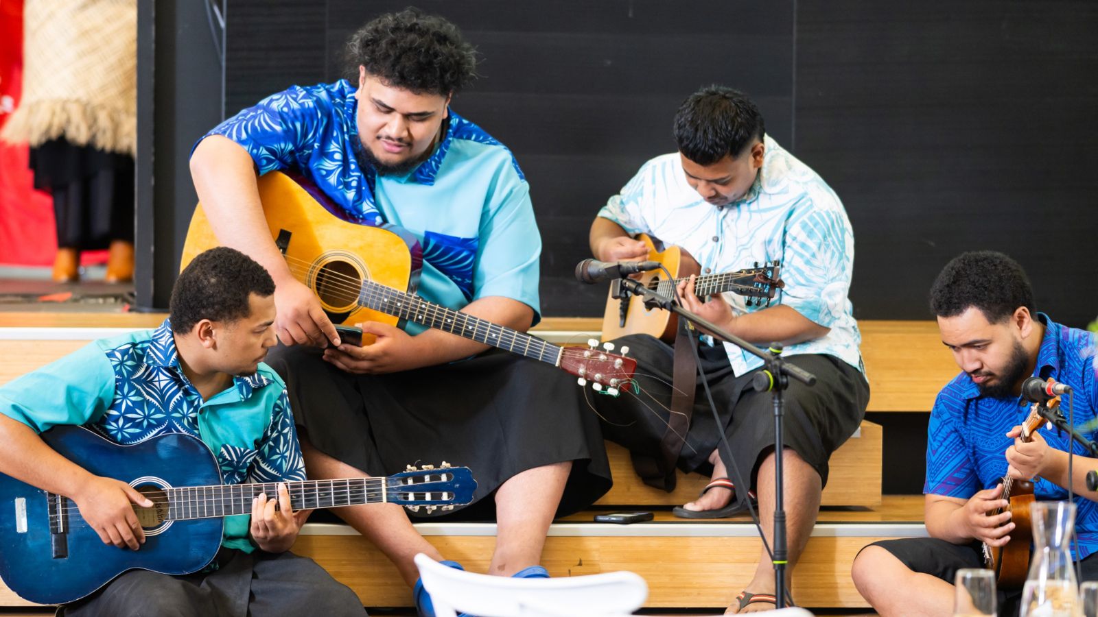Pasifika band boys quartet Four Pasifika boys sitting on the stage with guitars