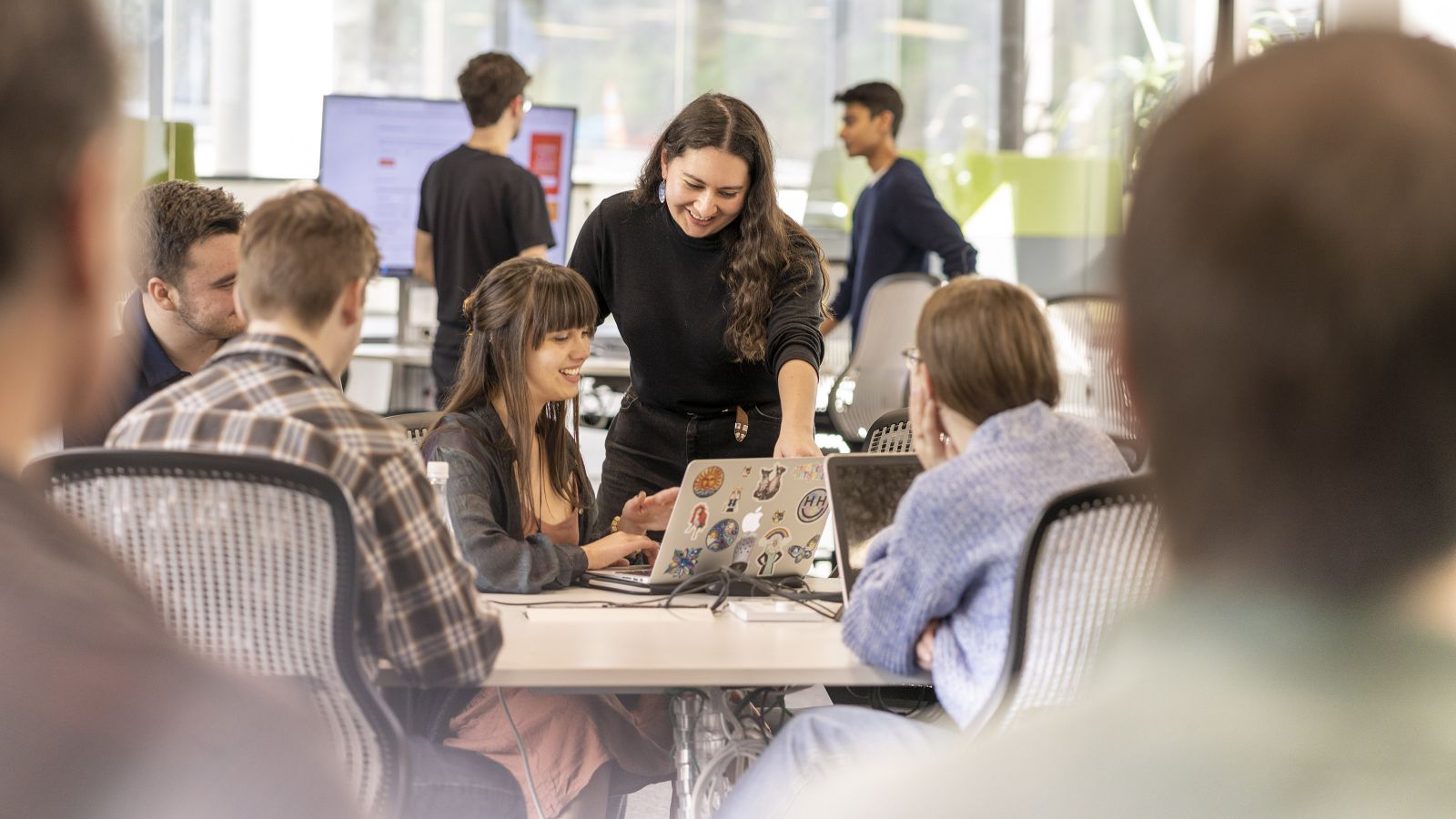 A group of students discusses something on a laptop with their teacher. Image copyright Dean Zillwood, used with permission.