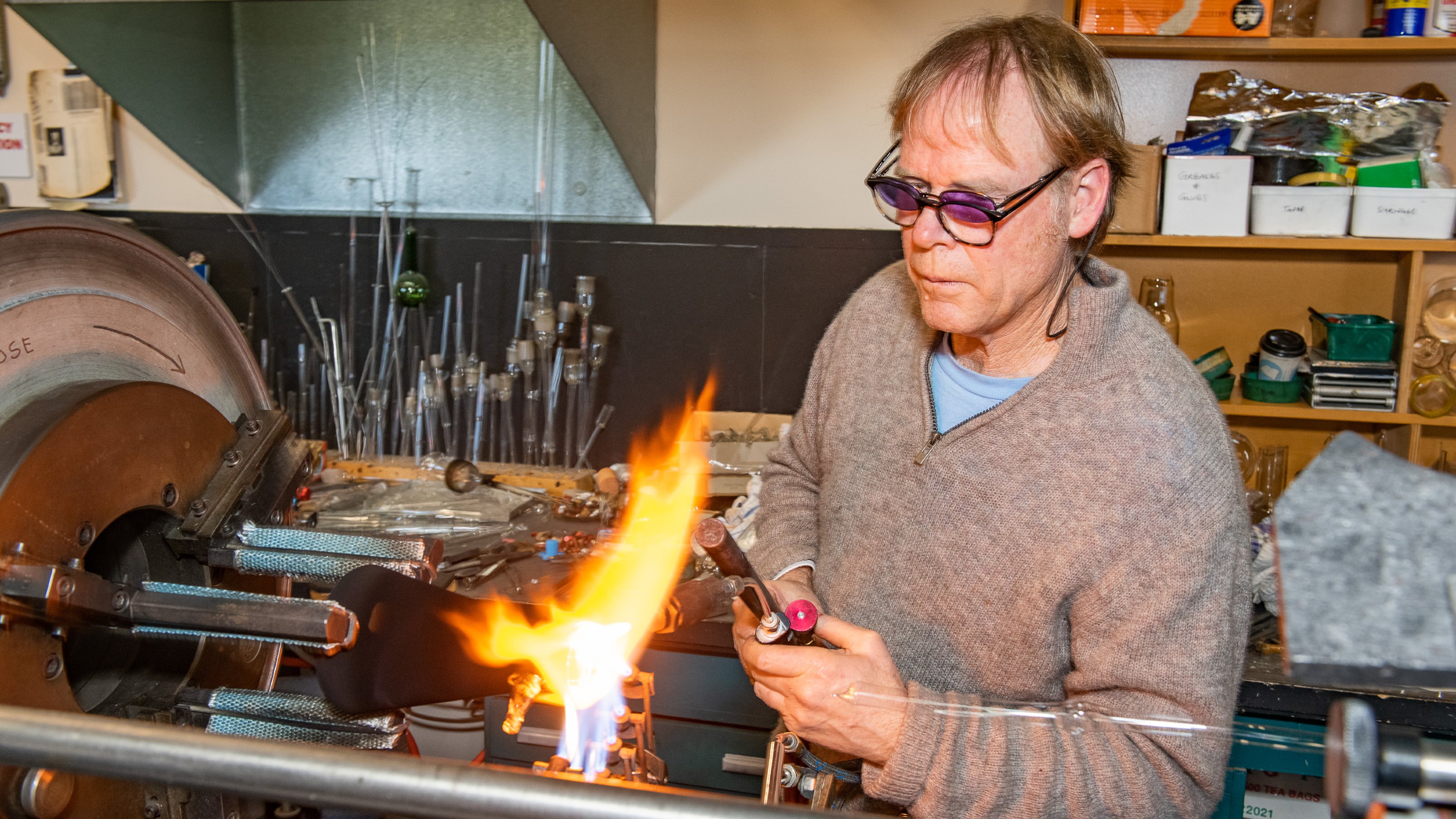 Man using blowtorch to shape glass