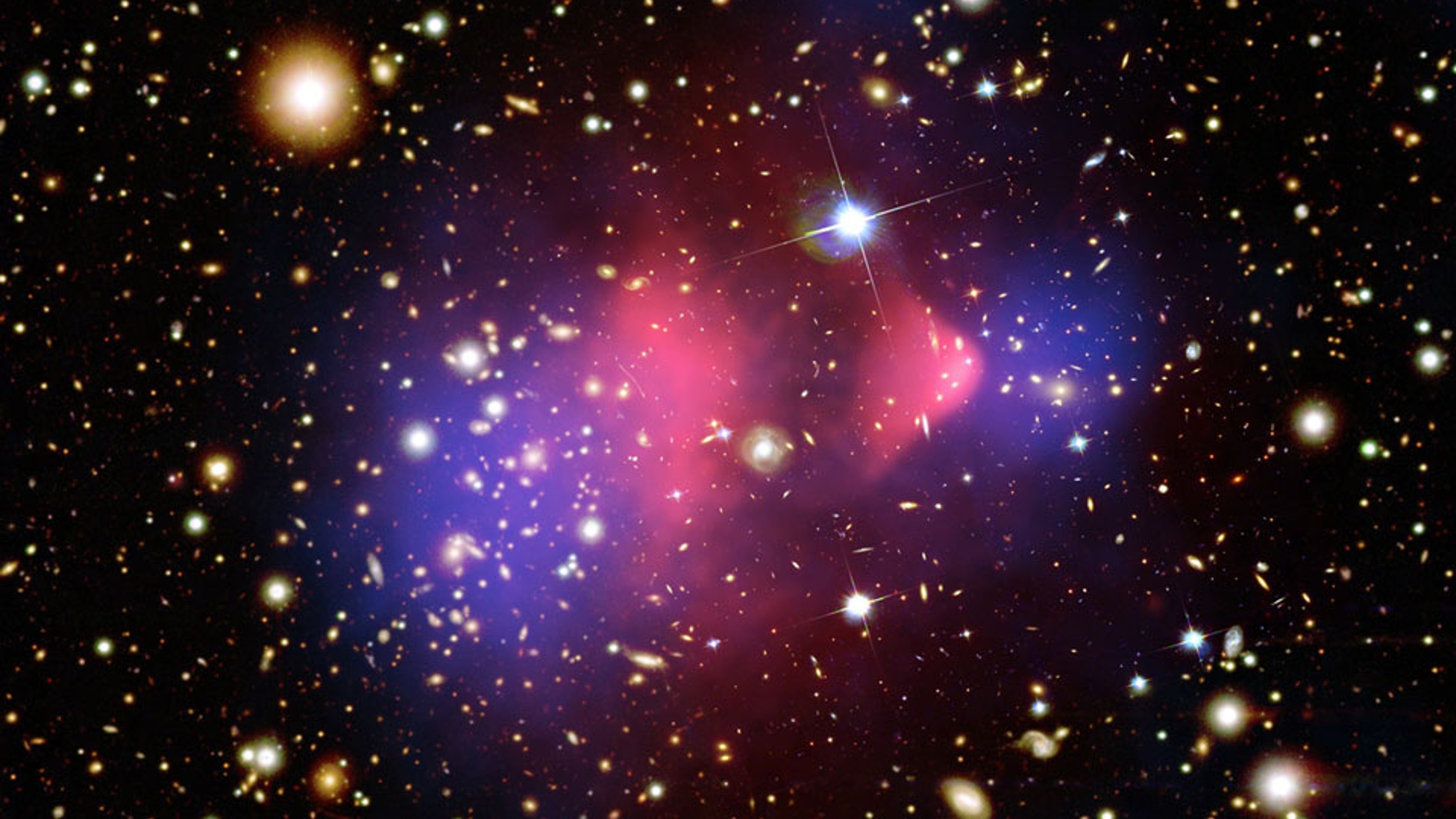 many stars on black background with amorphous pink-purple shape in the centre