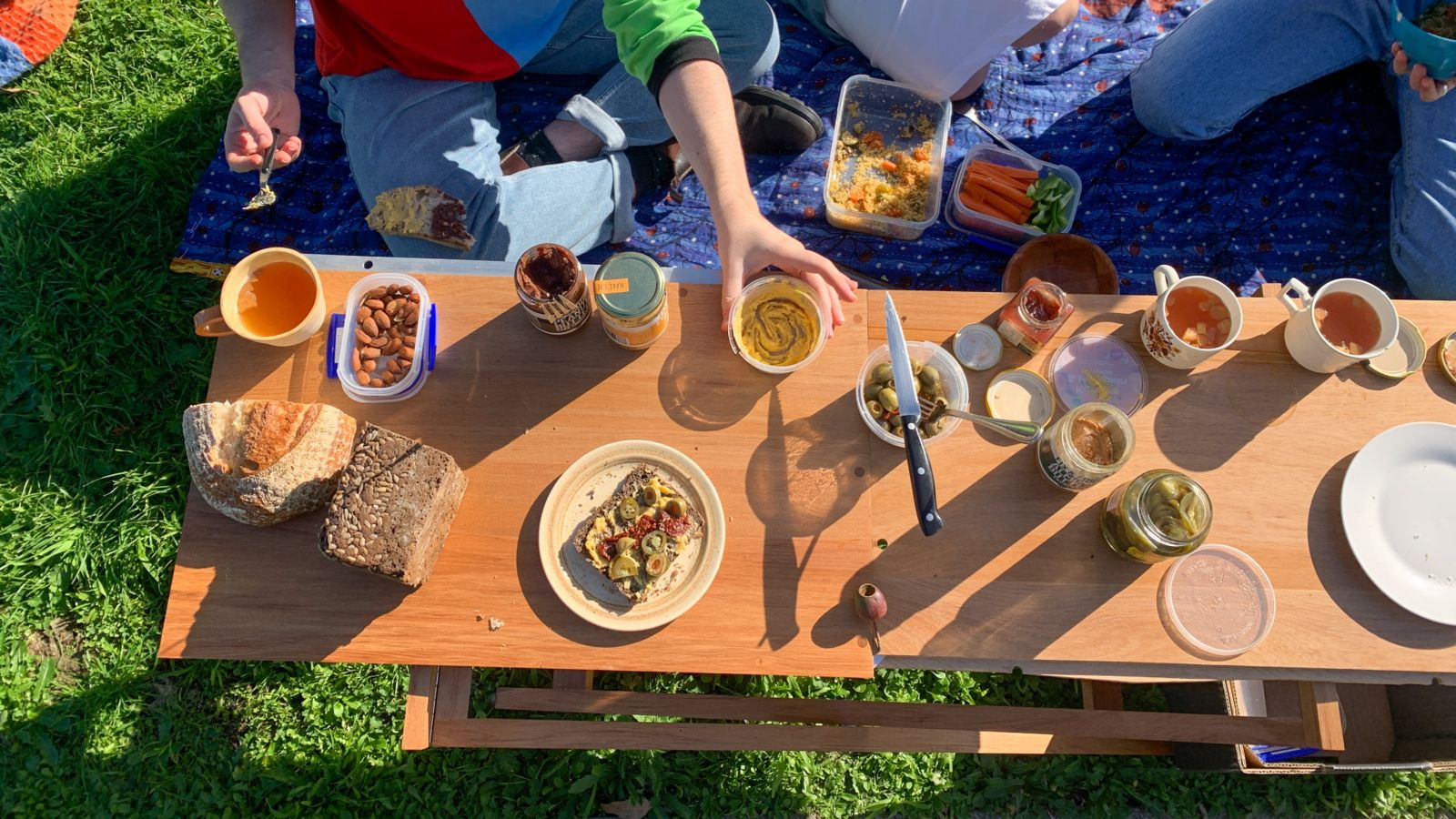 Zoe Glentworth table A to down view of a rimu table with food on at a picnic.