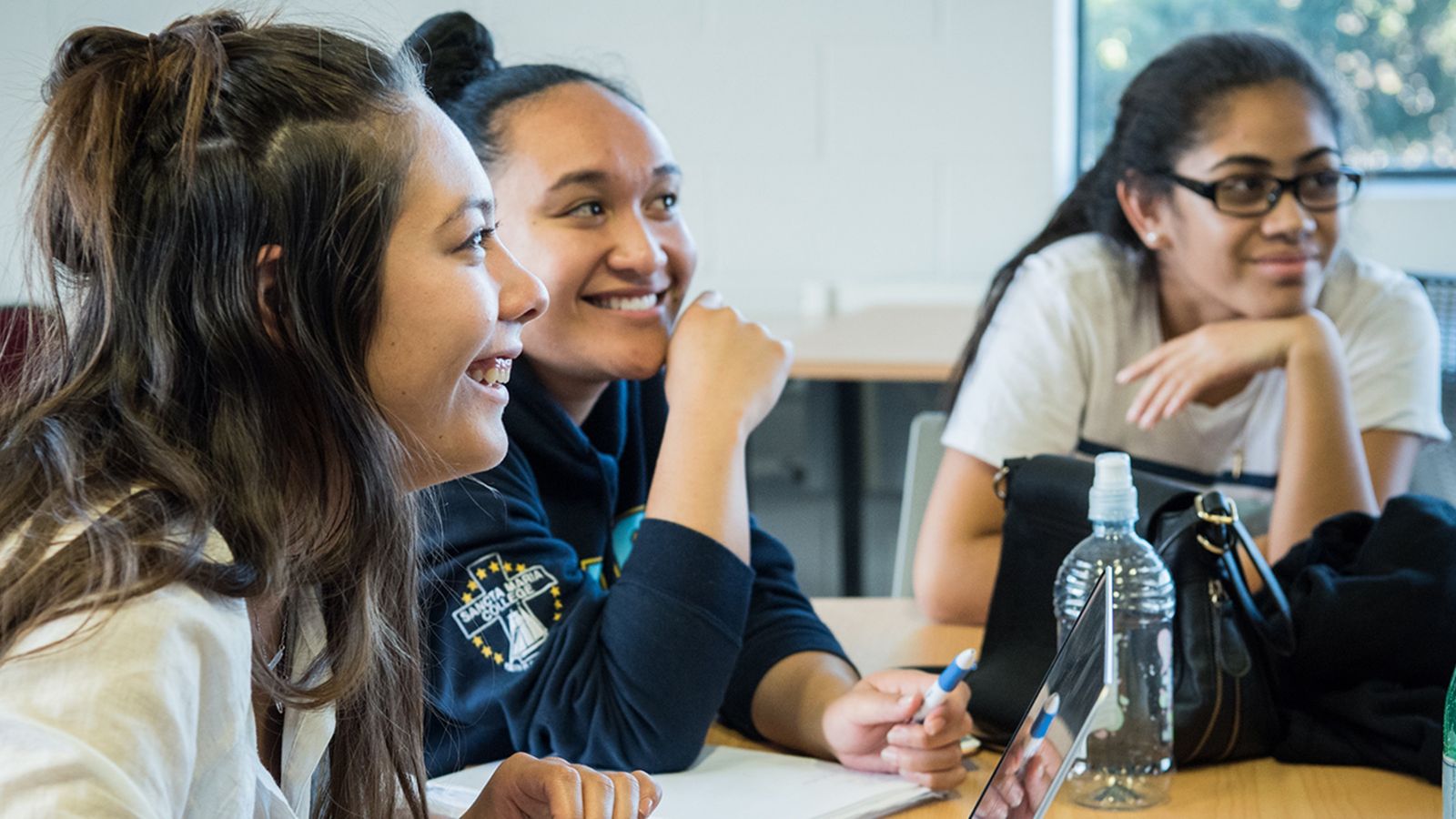 Three young women in a classroom