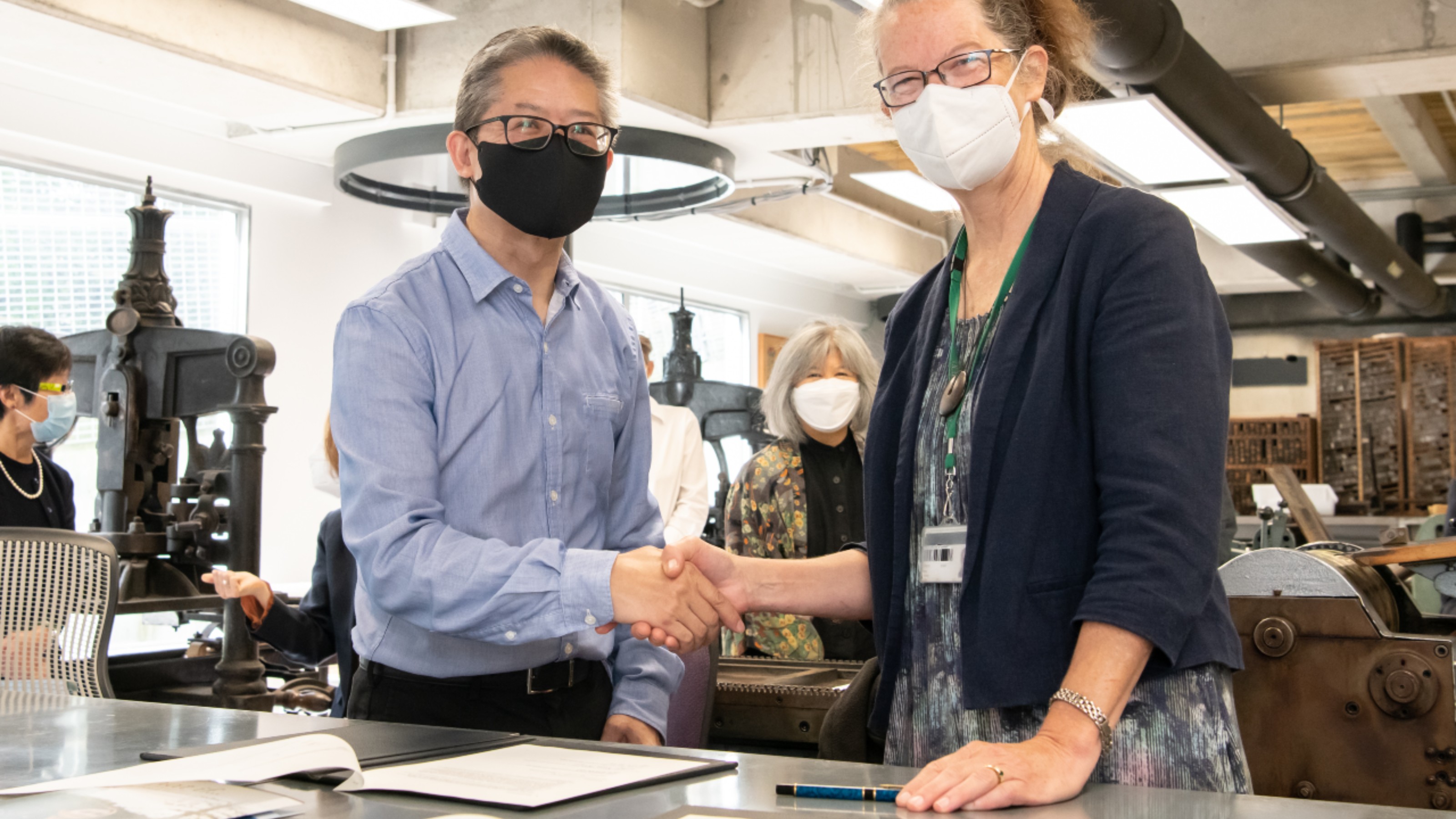 Keith Chan shakes hands with Dr. Sydney Shep at the gift signing ceremony